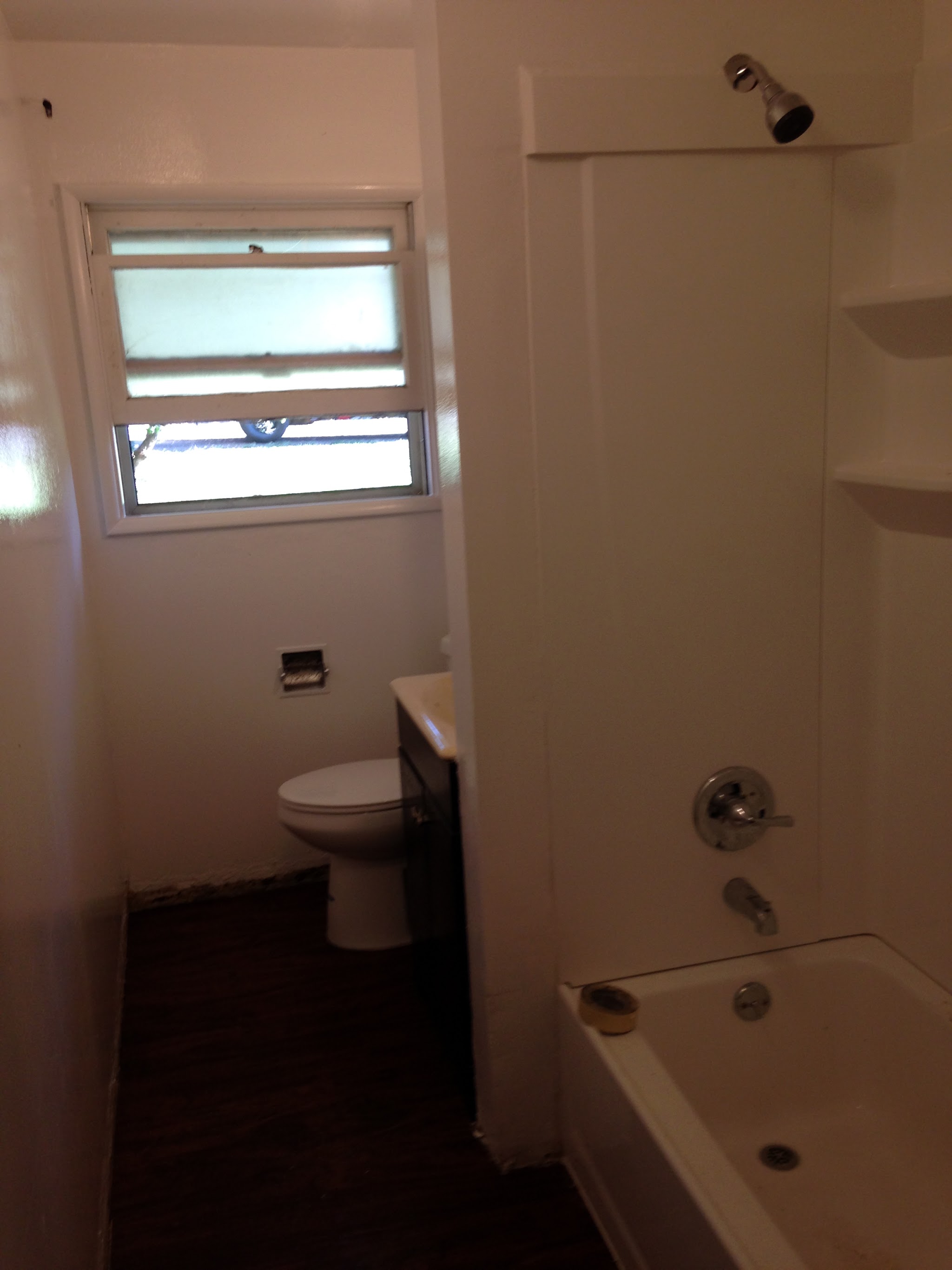 Freshly painted white bathroom interior with clean trim around the window