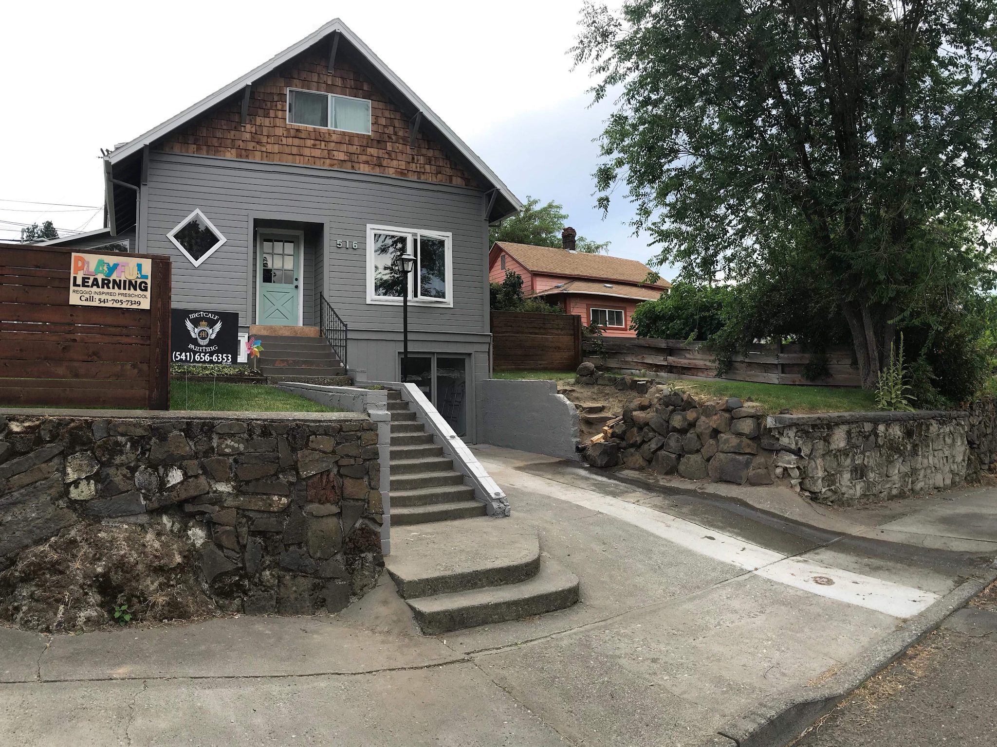 Grey craftsman home in Pendleton with cedar shingle gable and a pale teal front door