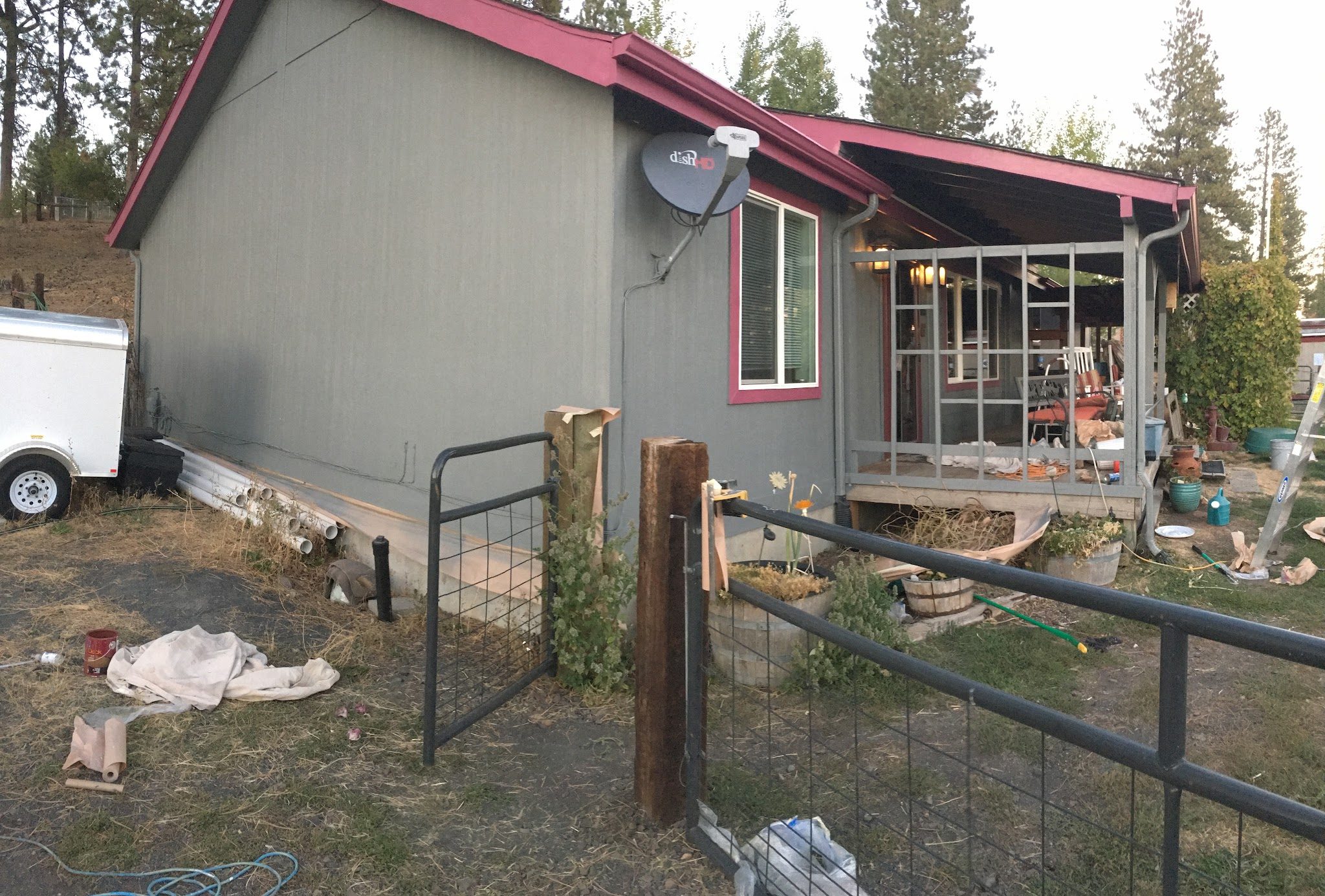 Single story home coated in gray with deep red trim and gutters